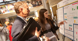 Photo of a teacher and student looking at a display board